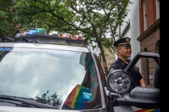 An NYPD officer stands by the department's new rainbow patrol car